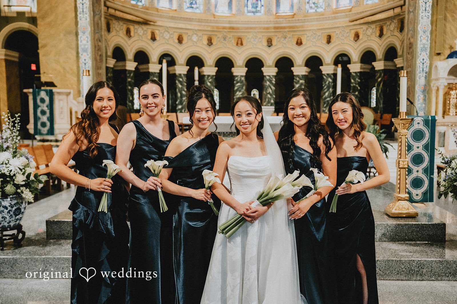 Aleksandar + Anna A bride standing with her bridesmaids who are wearing elegant black dresses.
