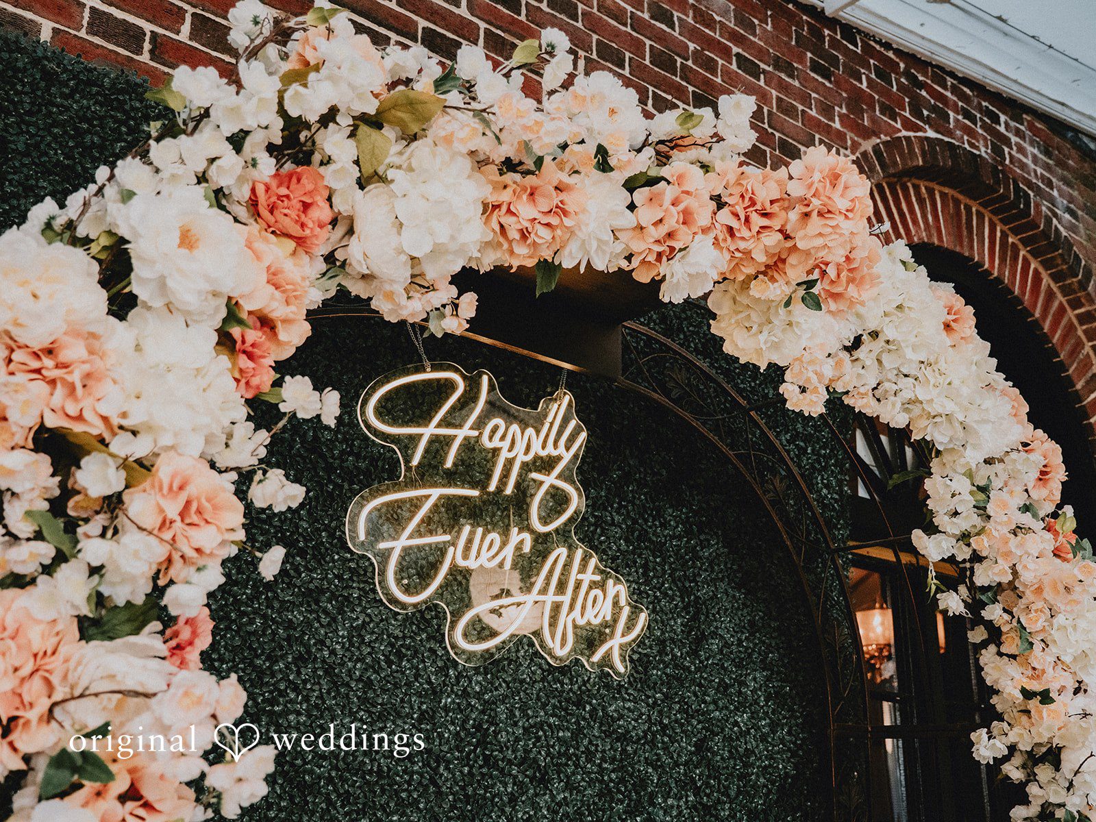 Aleksandar + Anna A floral arch decoration with a neon sign that reads "Happily Ever After".