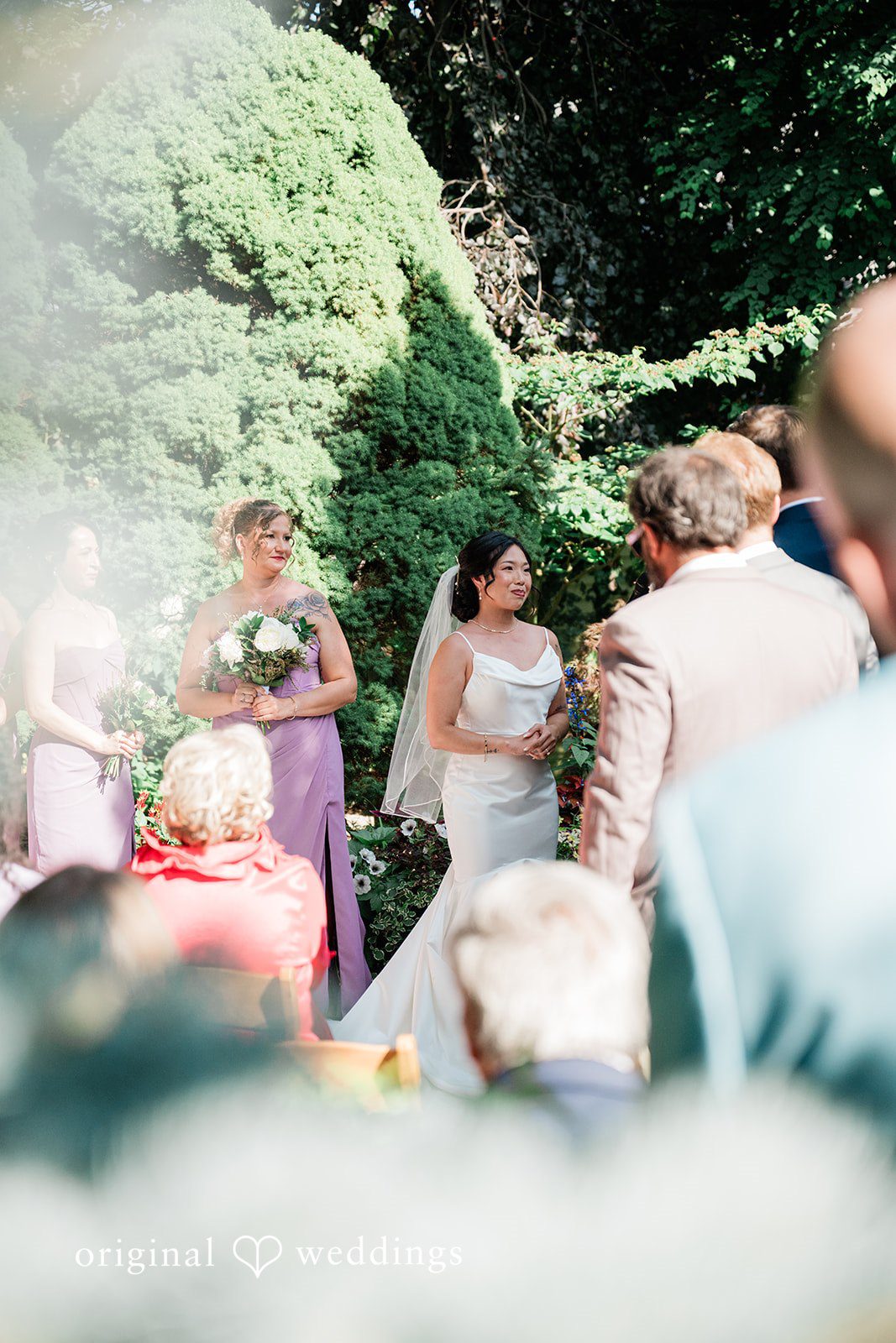 Lauren + Brinton Wedding guests standing in a garden setting during a ceremony.