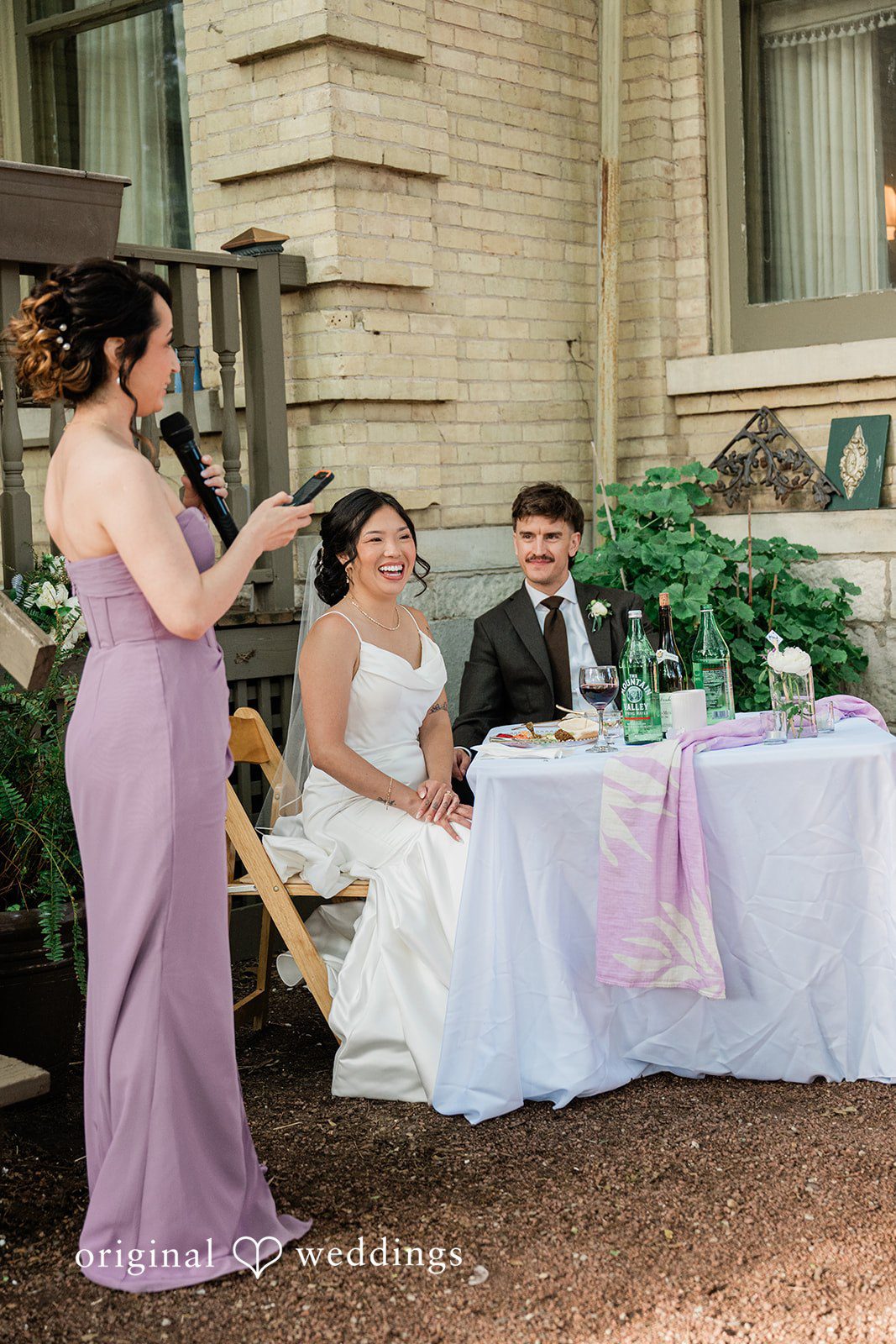 Lauren + Brinton A bridesmaid speaking into a microphone during a reception speech.