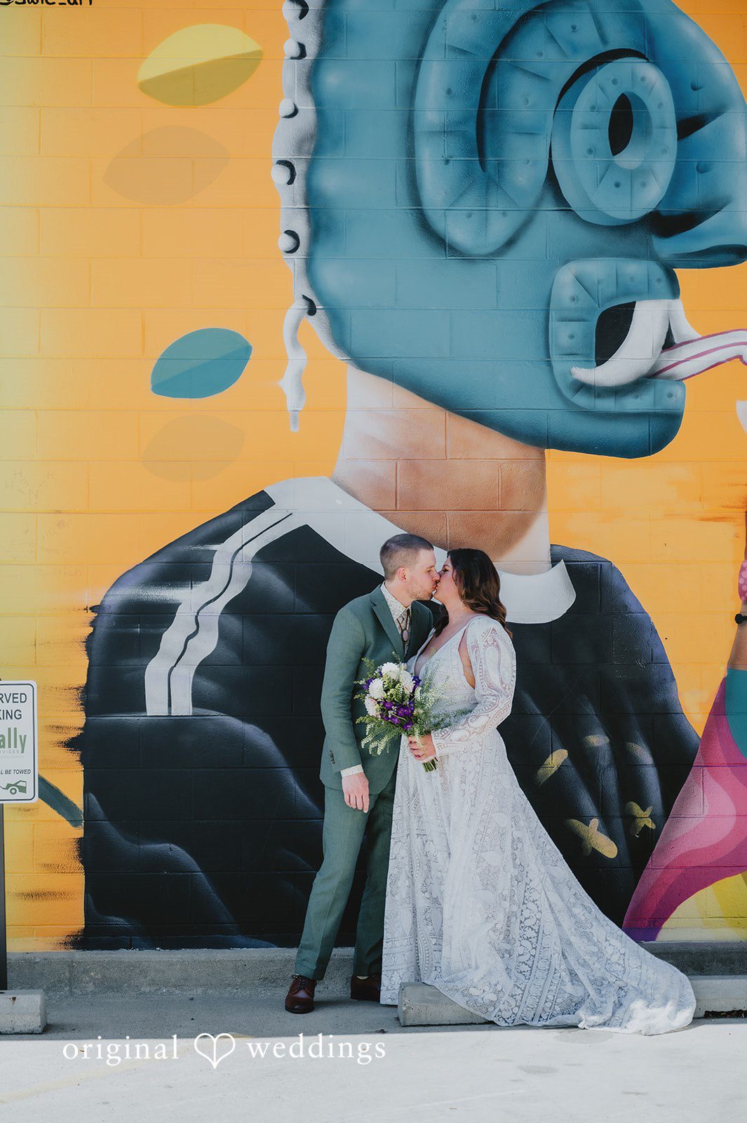Elizabeth + Willis Bride and groom posing together in front of a large, vibrant graffiti mural.