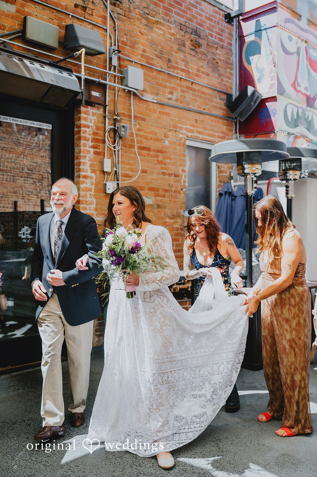 Elizabeth + Willis Bride laughing while walking down a street surrounded by wedding guests.