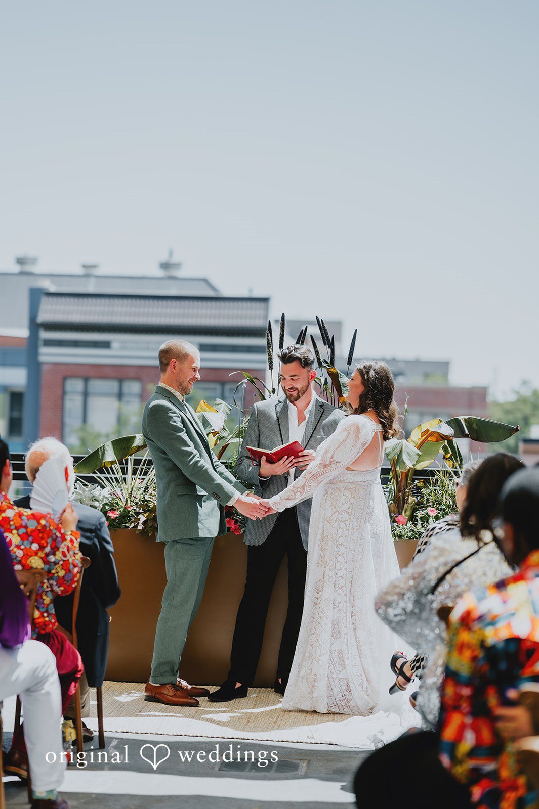 Elizabeth + Willis Couple standing at an altar surrounded by wedding guests.