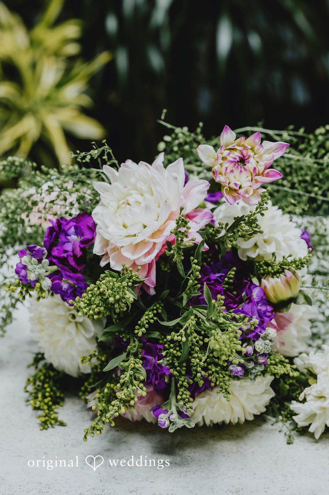 Elizabeth + Willis Close-up of a lush floral arrangement featuring purple, pink, and white blossoms.