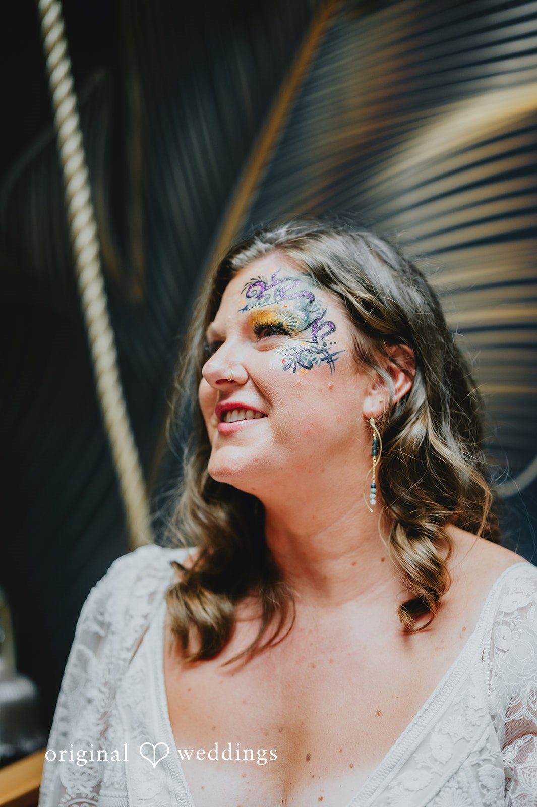 Elizabeth + Willis Side profile of a smiling bride wearing glittery face makeup.