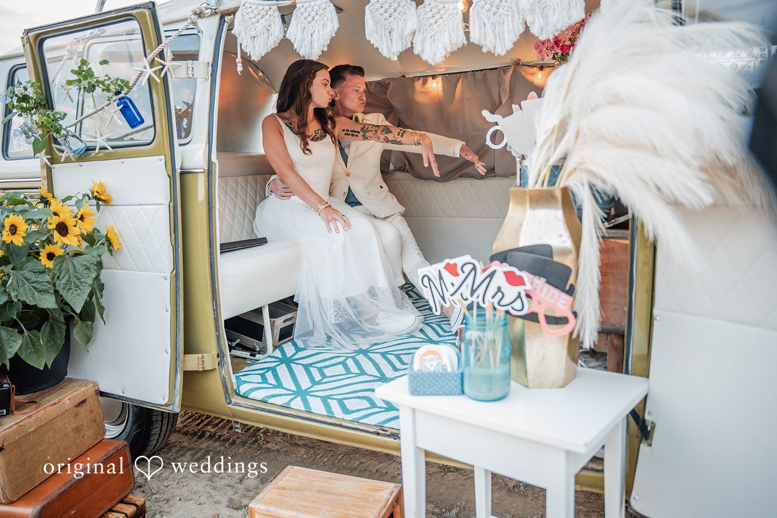Jacqueline + Sarah A bride and groom sitting inside a decorated vintage van.