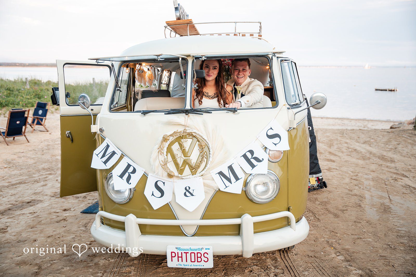 Jacqueline + Sarah The back of a yellow vintage van adorned with a "Mr. & Mrs." sign.