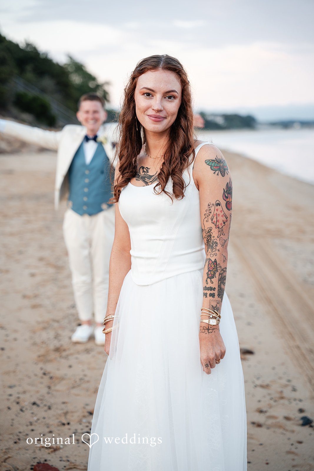 Jacqueline + Sarah A bride and groom standing side-by-side smiling together.