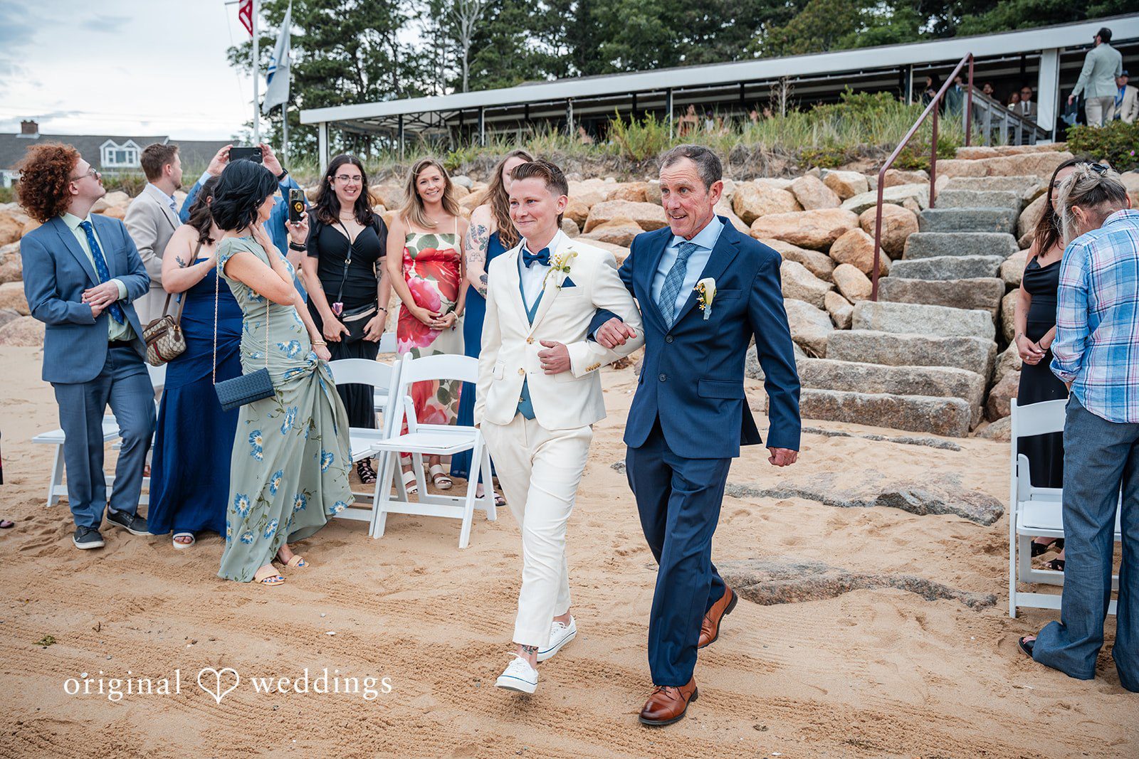 Jacqueline + Sarah A groom walking down the aisle with man at beachside ceremony.