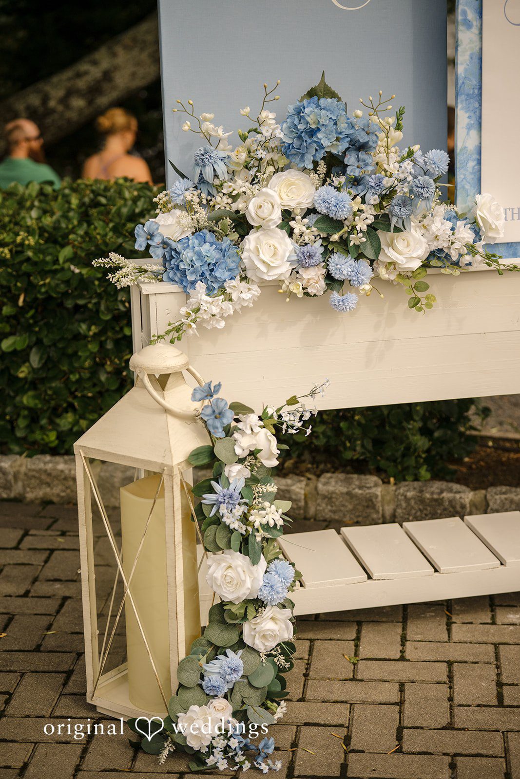 Morgan + Colin A white decorative shelf adorned with blue and white wedding florals.