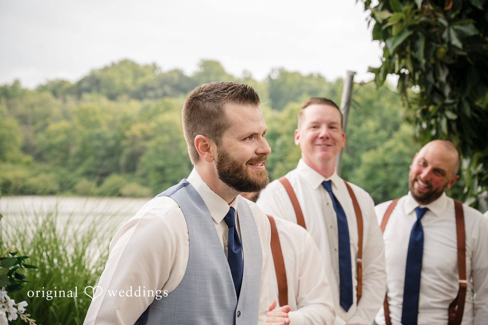 Morgan + Colin A groom laughing alongside his groomsmen clad in light blue ties and suspenders.