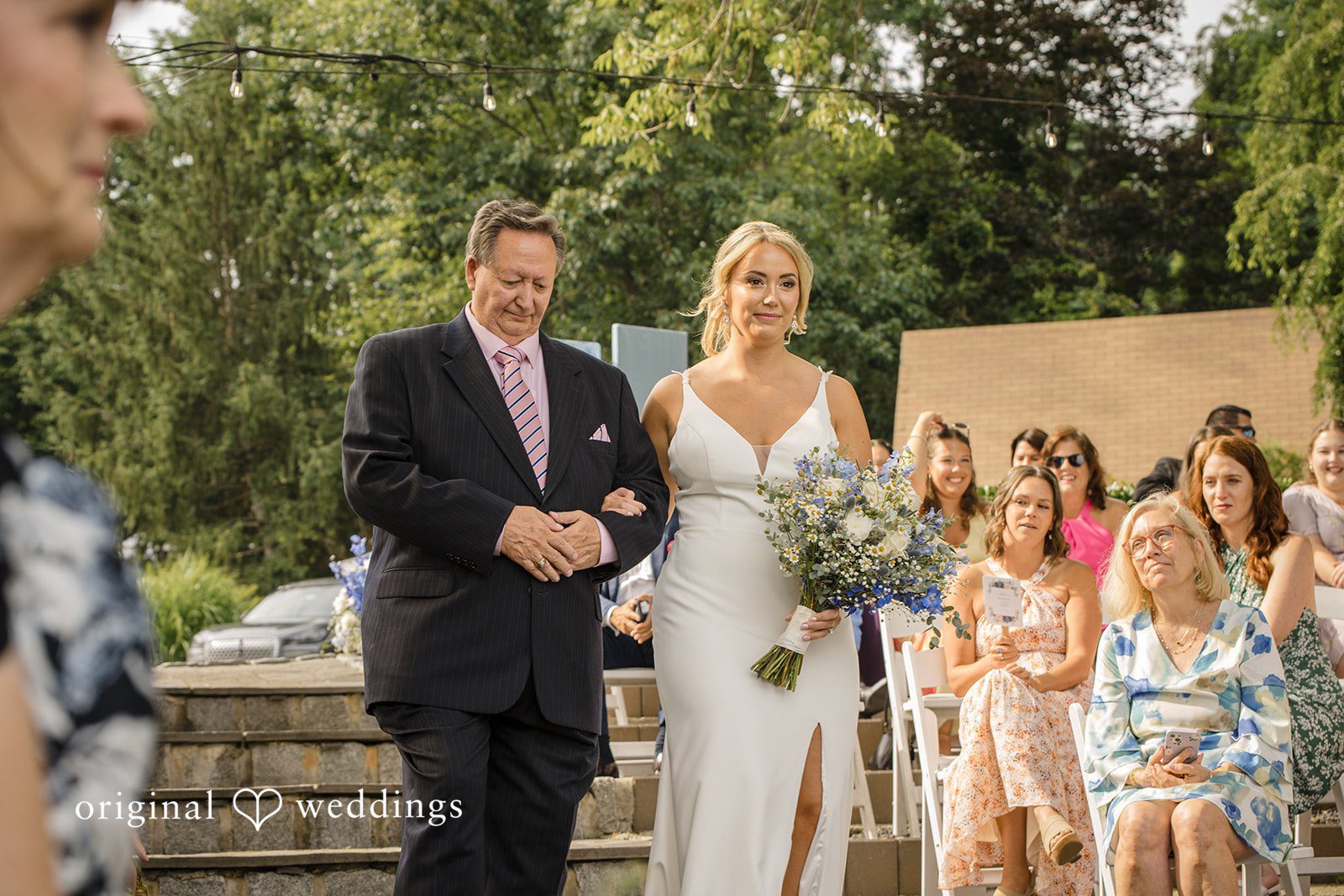Morgan + Colin A bride walking down the aisle accompanied by an older gentleman.