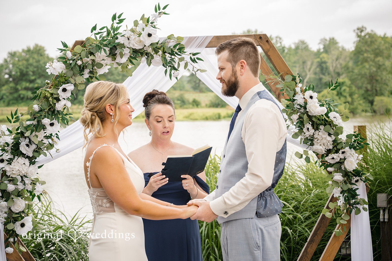 Morgan + Colin A bride placing a wedding ring on the groom's finger during the ceremony.