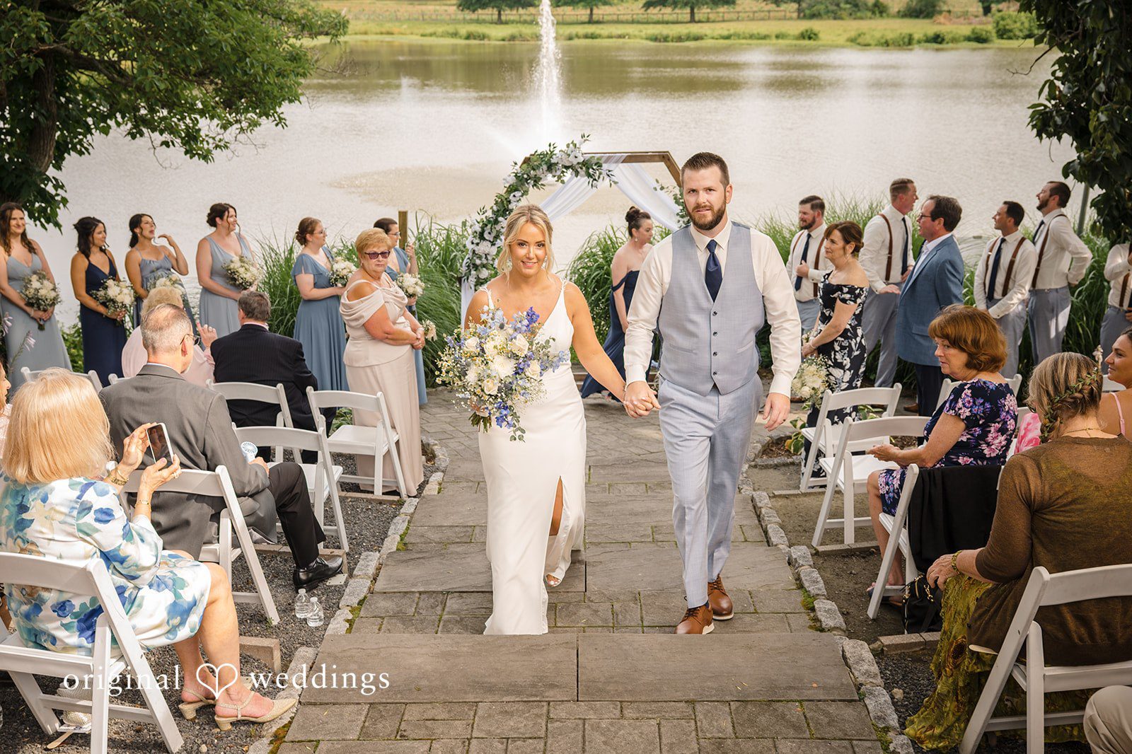 Morgan + Colin A bride and groom walking down the aisle together as wedding guests applaud.
