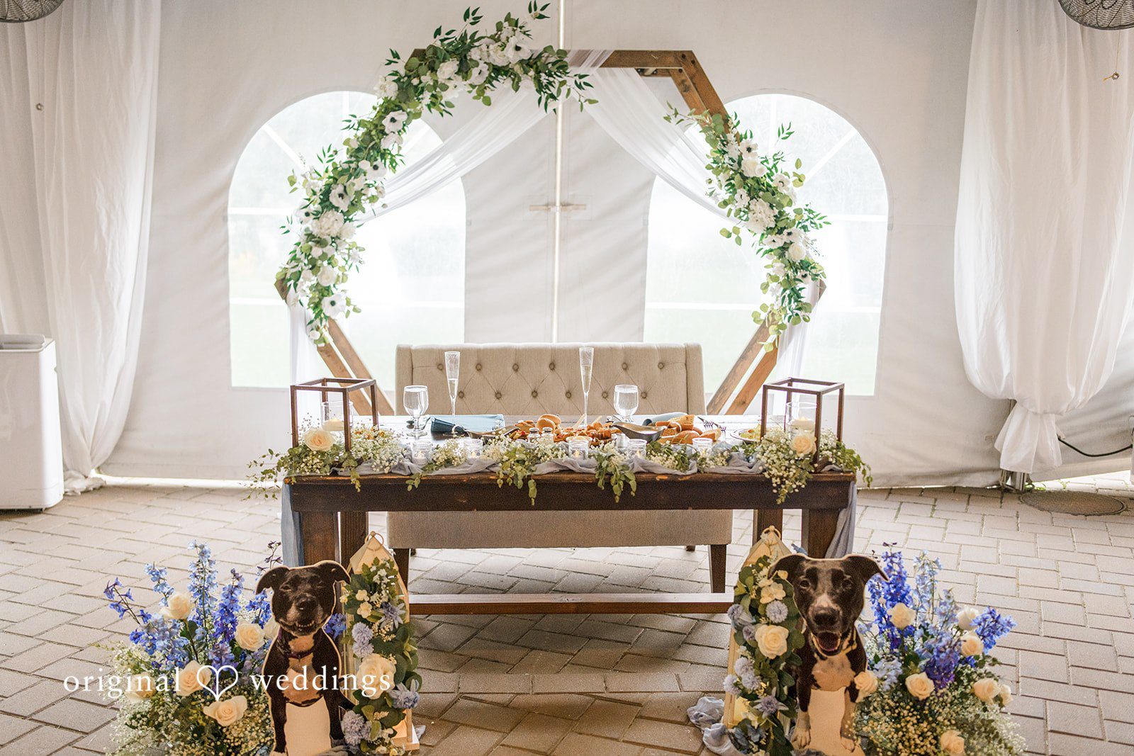 Morgan + Colin A wooden sweetheart table framed by a circular floral wedding arch.
