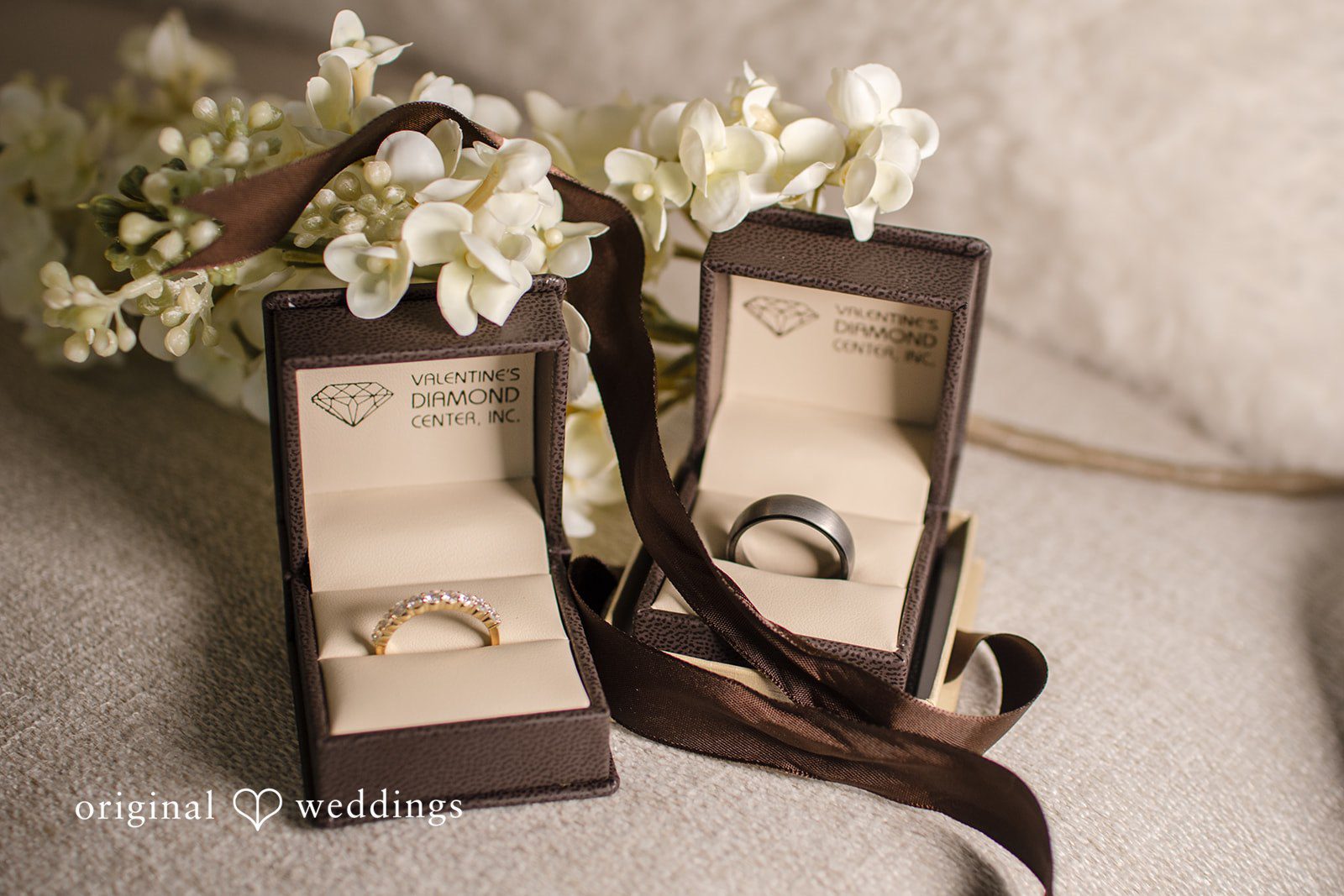 Alice-sun + Michael Close up shot wedding rings placed beautifully along with the flowers and a ribbon