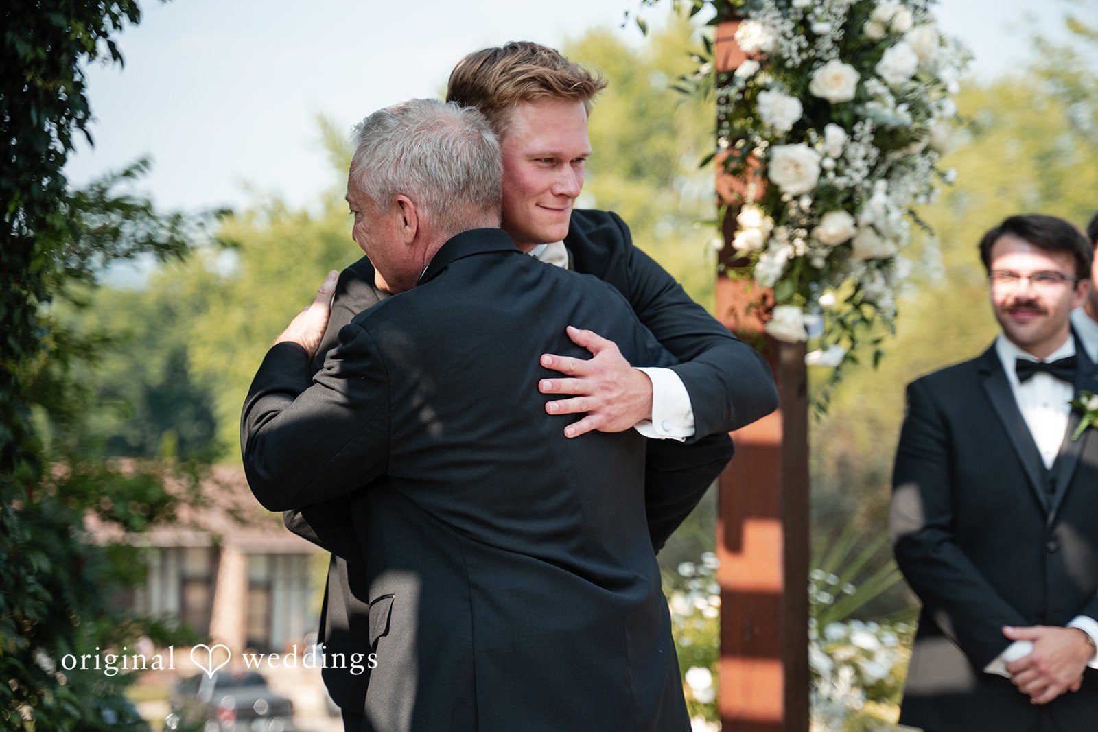 Nikki + Charlie The groom and bride's father shares a passionate hug