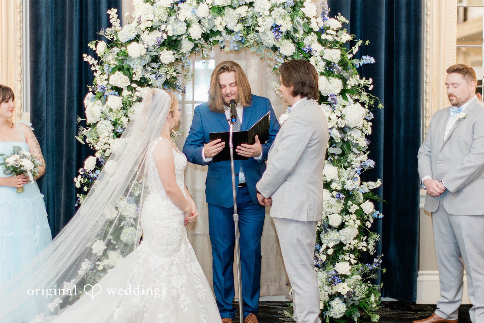 Sara + Michael A wedding ceremony in progress with an officiant standing between the bride and groom.
