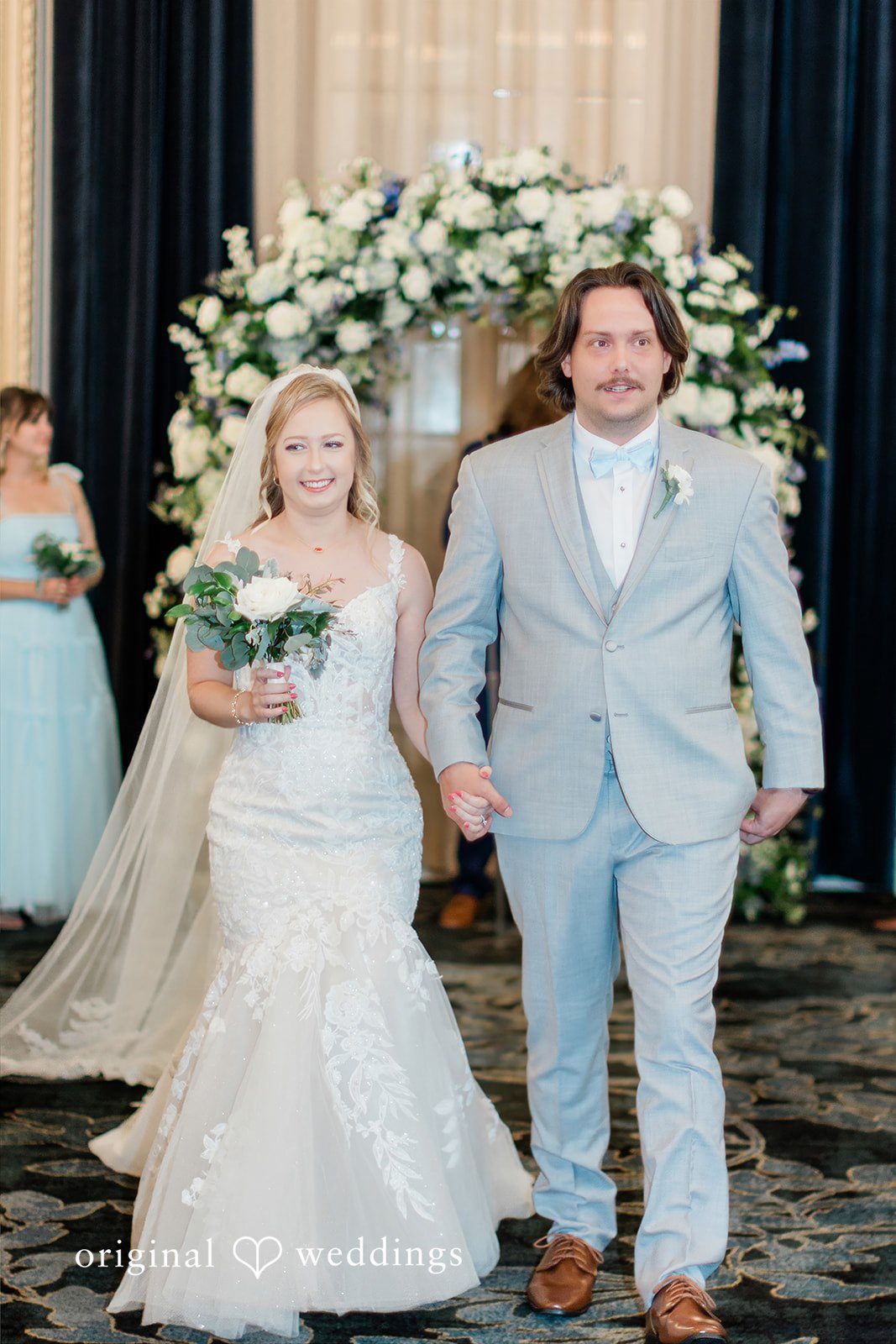 Sara + Michael A bride and groom walking down the aisle together smiling after getting married.