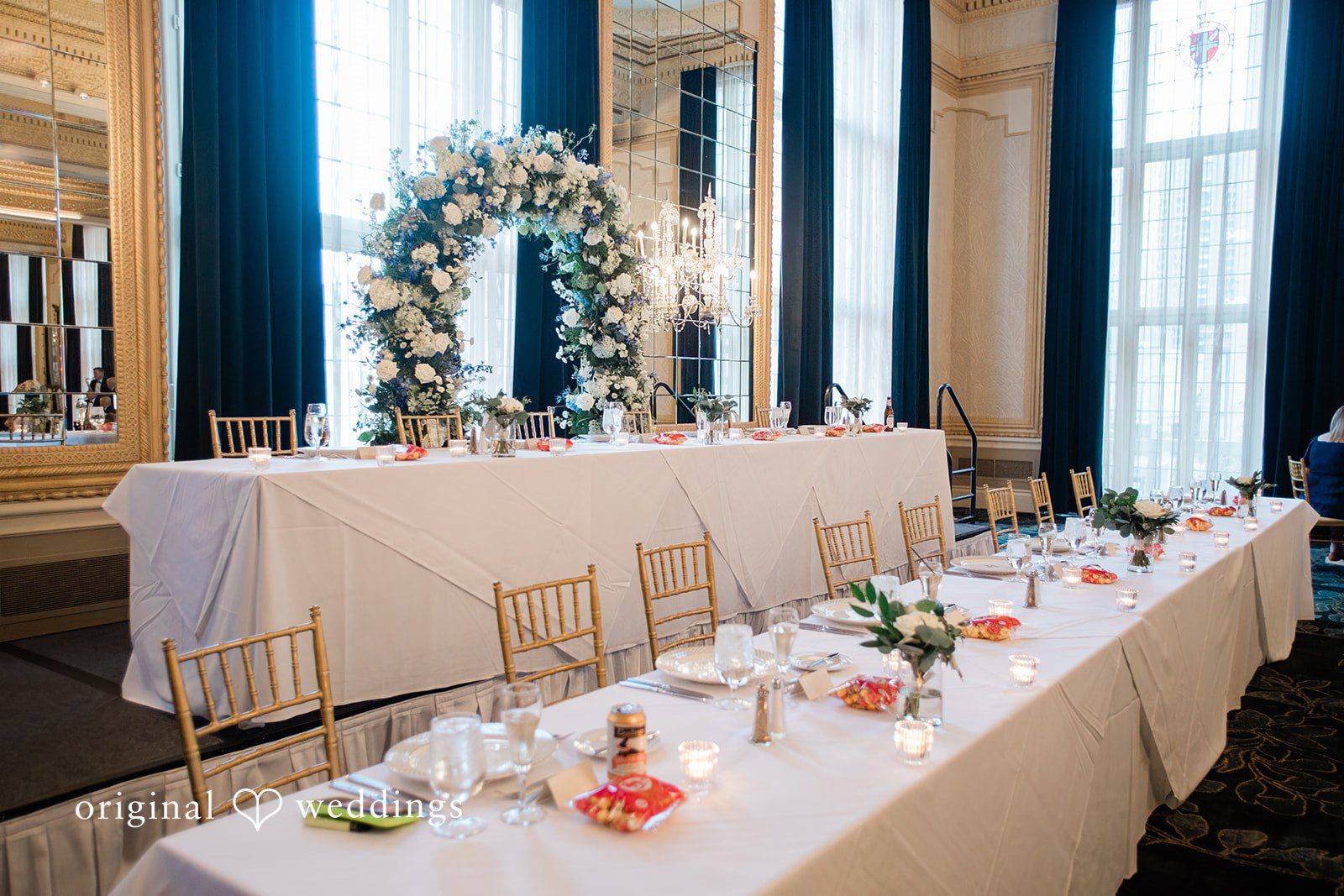 Sara + Michael An elevated view of a long reception table set with elegant centerpieces and glassware.