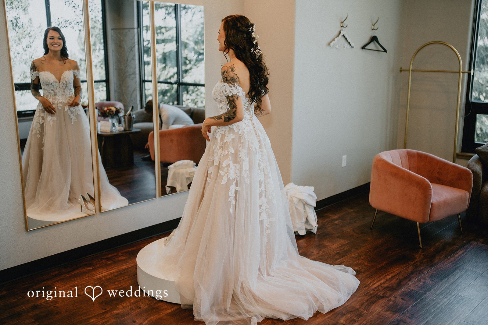 Jennifer + Danielle A bride in a white wedding gown stands in front of a mirror.