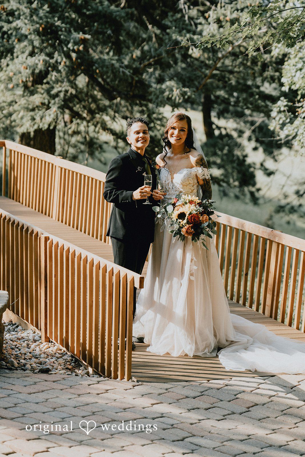 Jennifer + Danielle A couple walks together down a wooden walkway after their wedding.