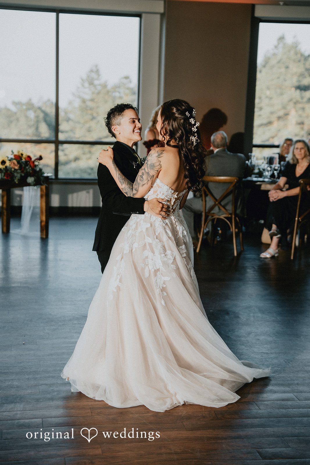 Jennifer + Danielle A couple share their first dance in front of seated guests.