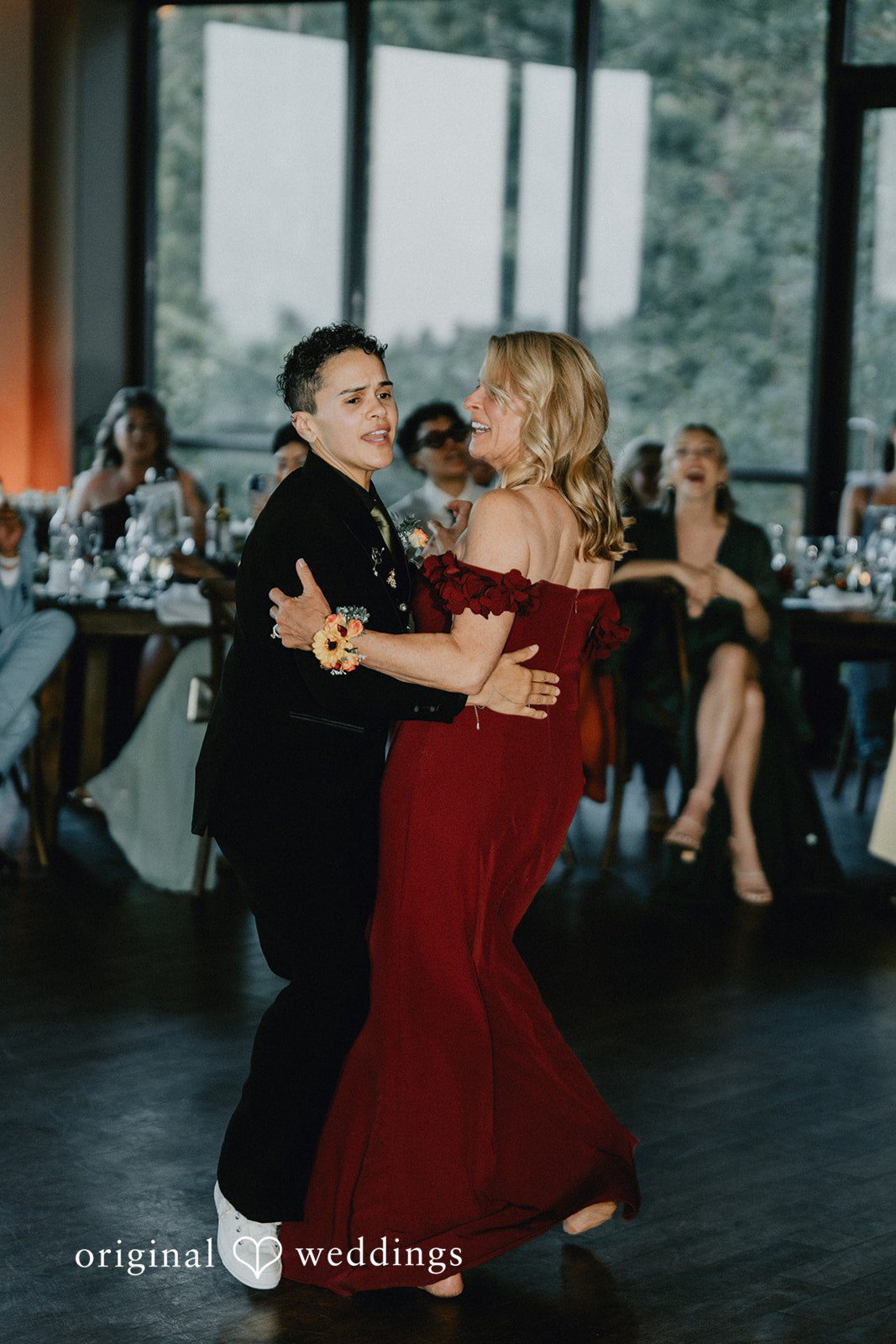 Jennifer + Danielle A groom dances with a guest in a red dress during the reception.