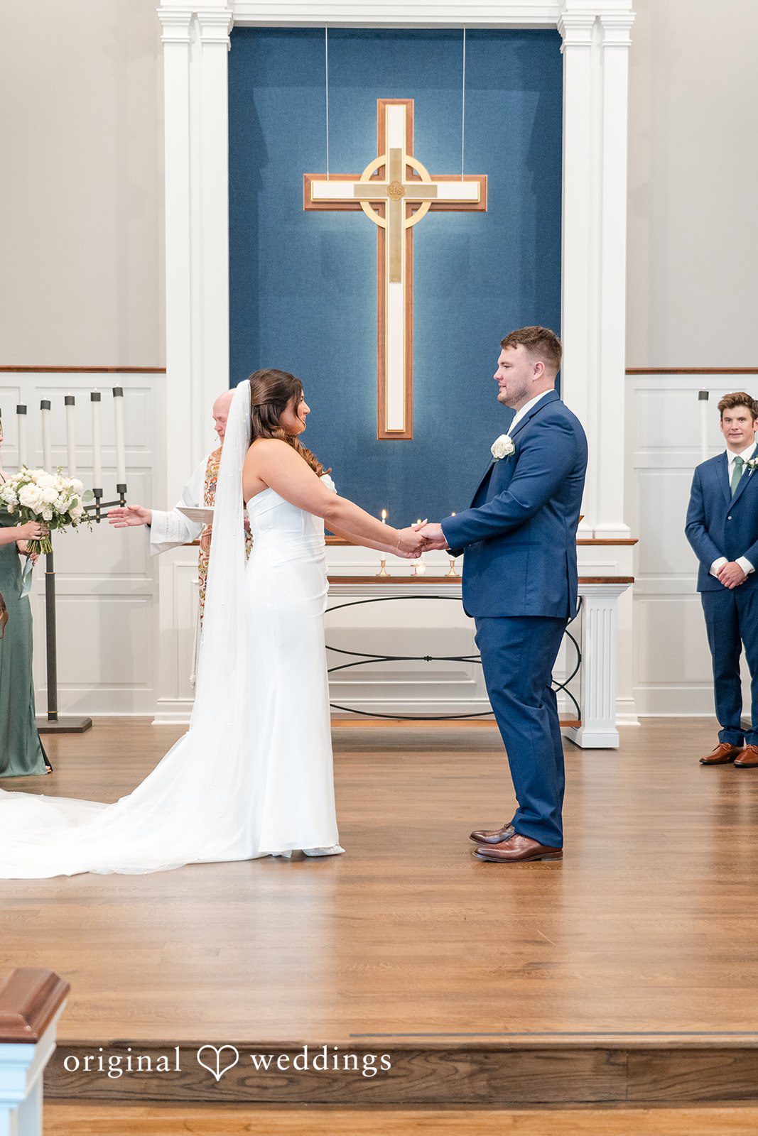 Chelsea + Matthew Milwaukee Wedding Photographers capturing couple holding hands and looking at each other in front of the priest at The Rivulet by Original Weddings