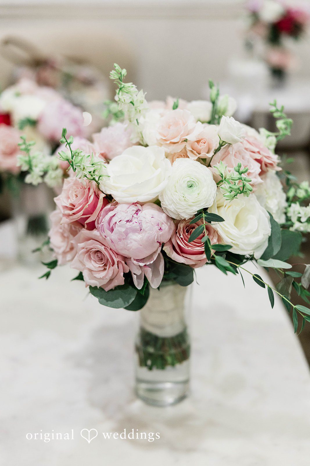 A lush wedding bouquet featuring light pink and white flowers.