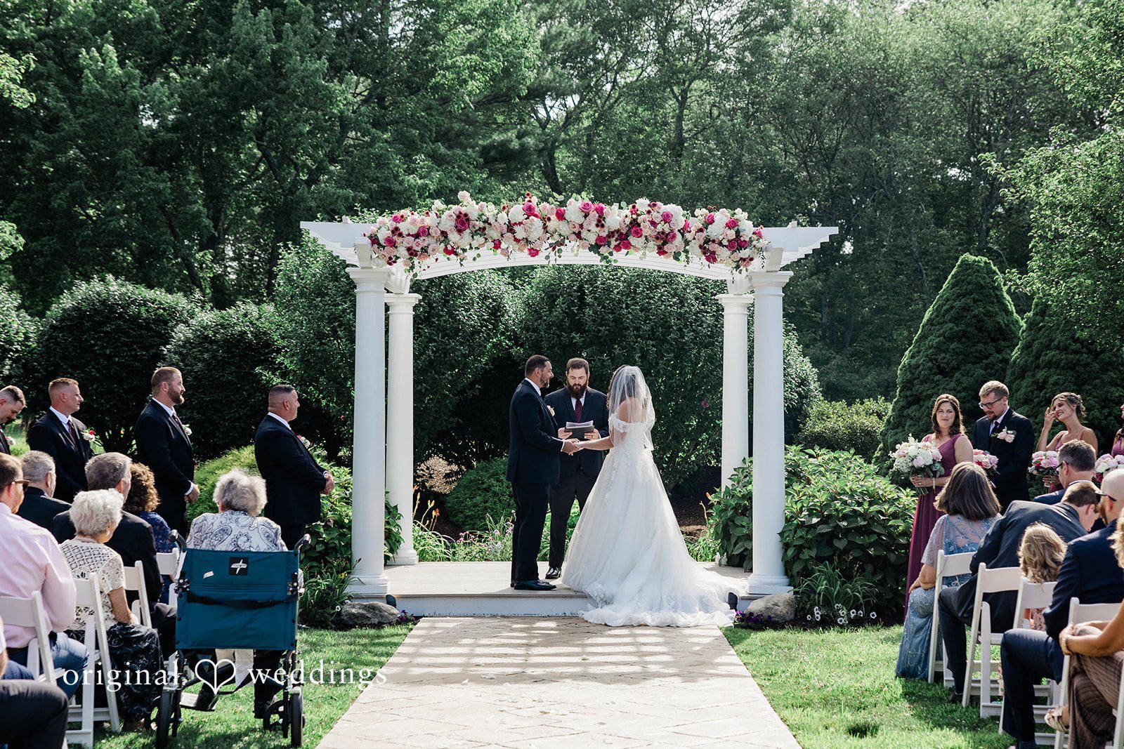 Wedding ceremony in progress with guests seated in rows.