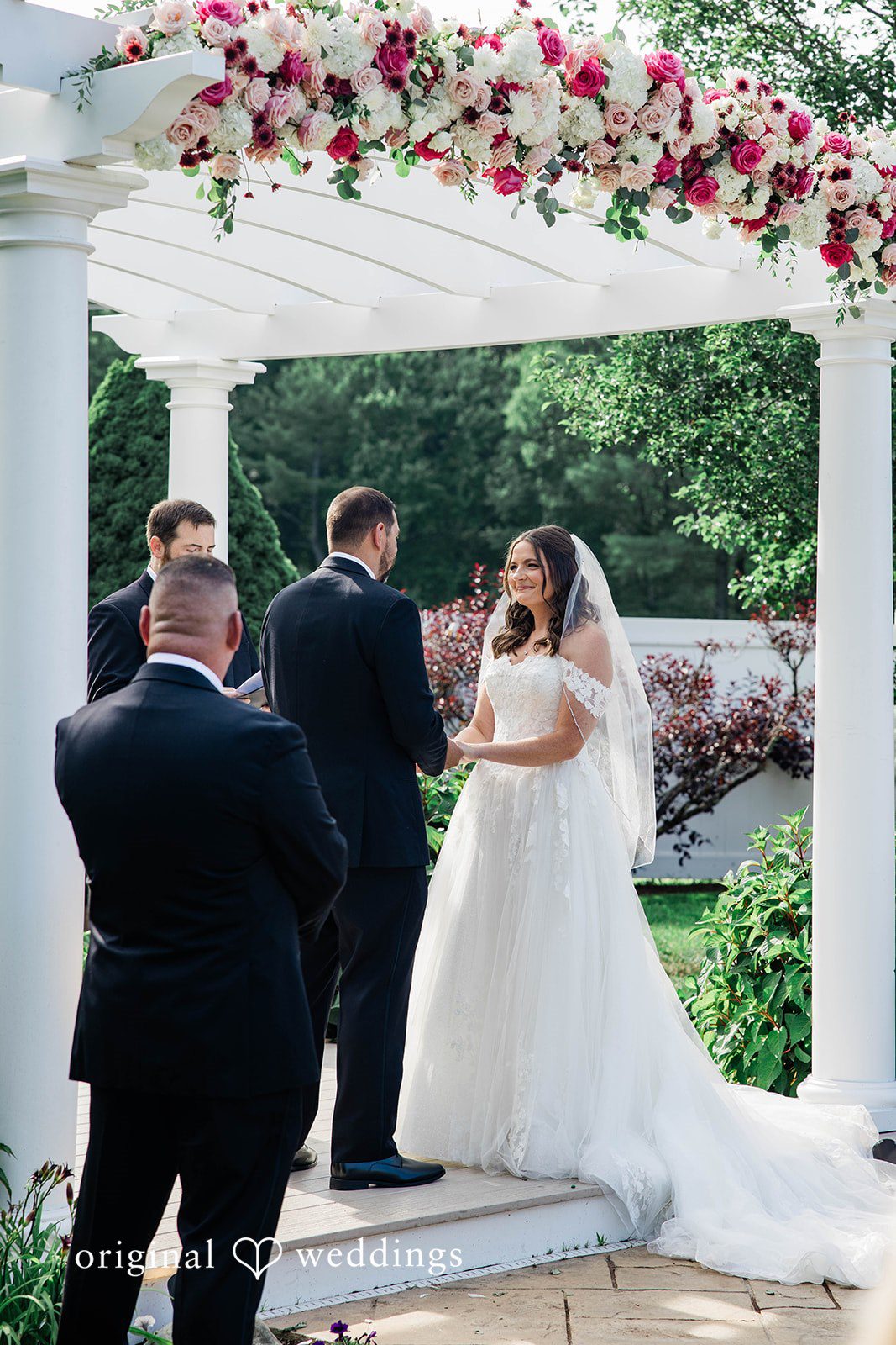 A bride and groom standing an altar during their ceremony.