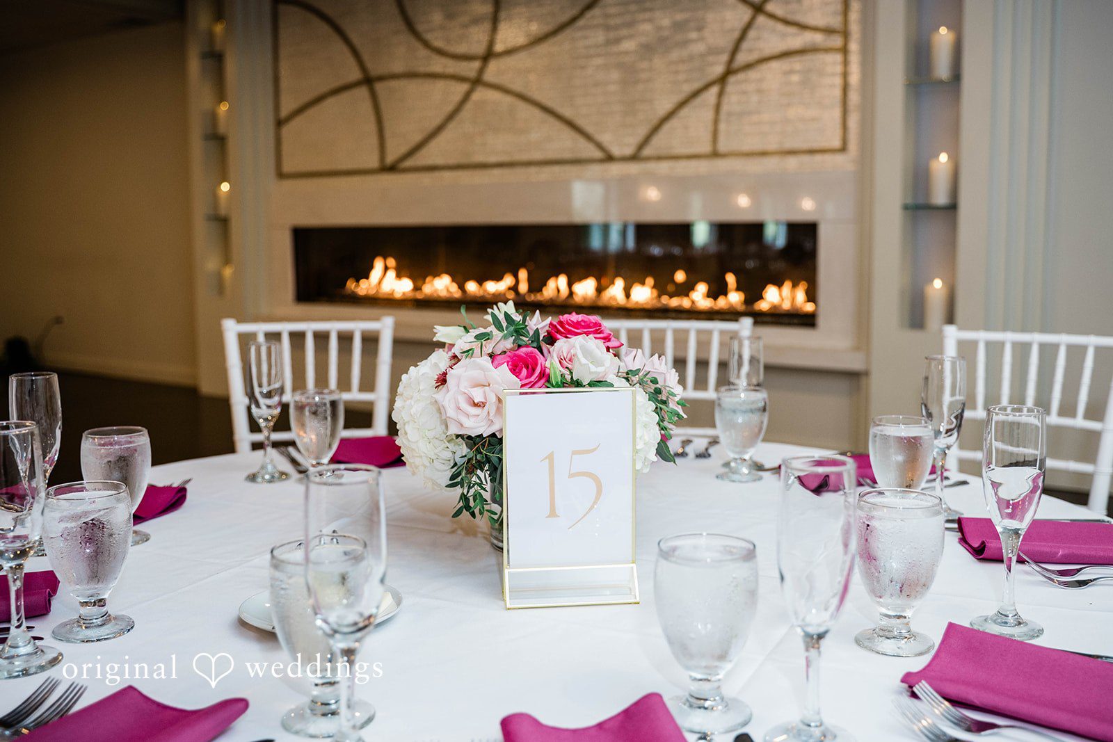 A brightly lit wedding venue featuring a stone fireplace.