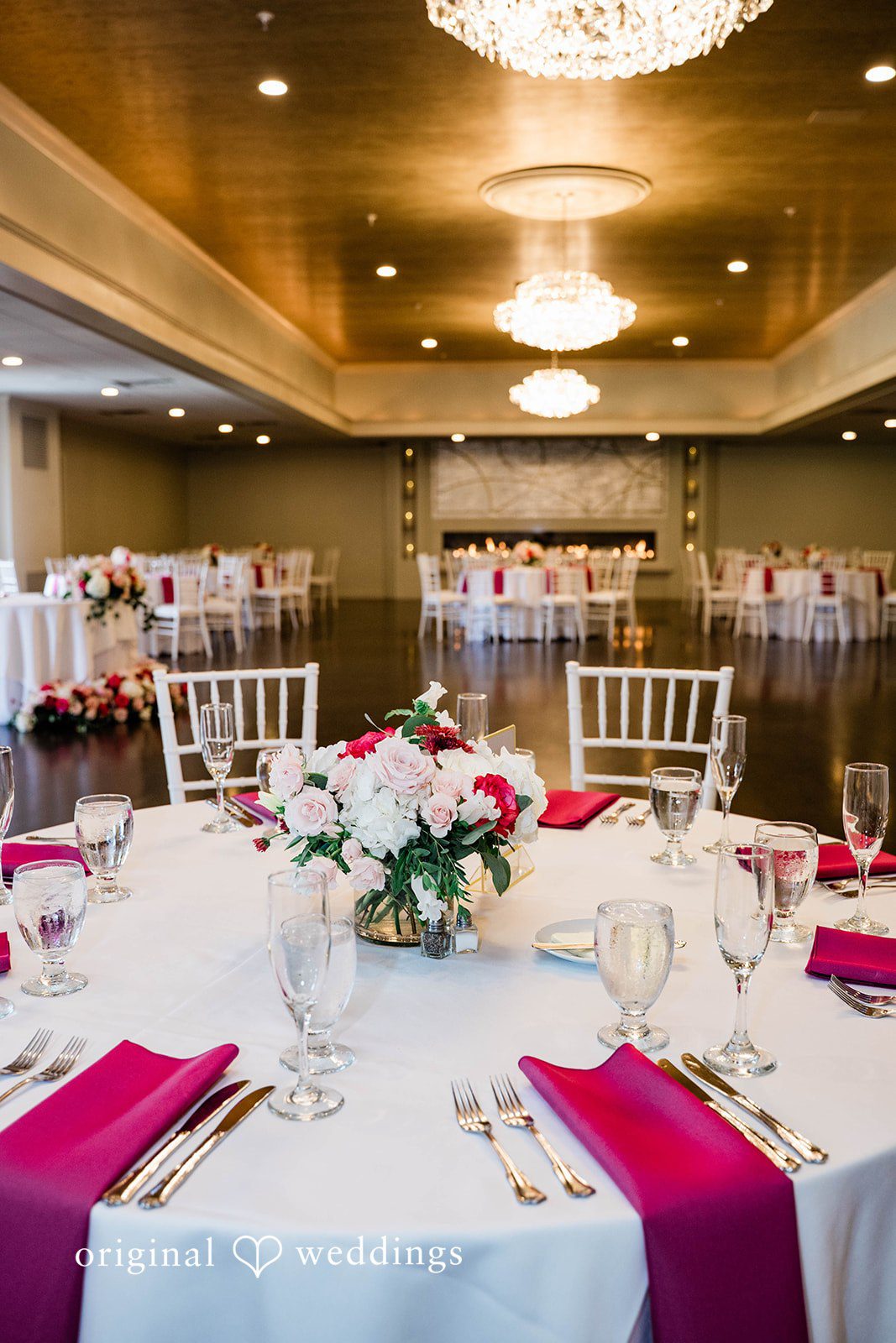 A close-up view of a wedding table setting with pink napkins.
