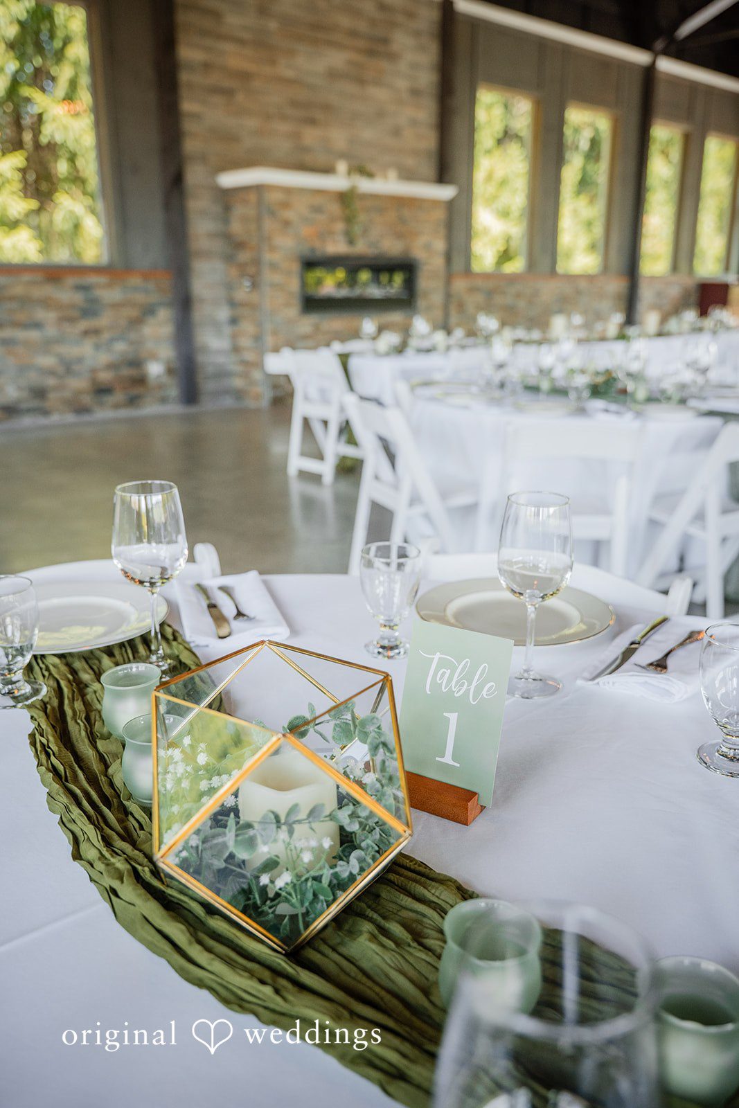 Zechariah + Tova A decorated wedding reception table set with glasses, floral centerpieces, and white linens.