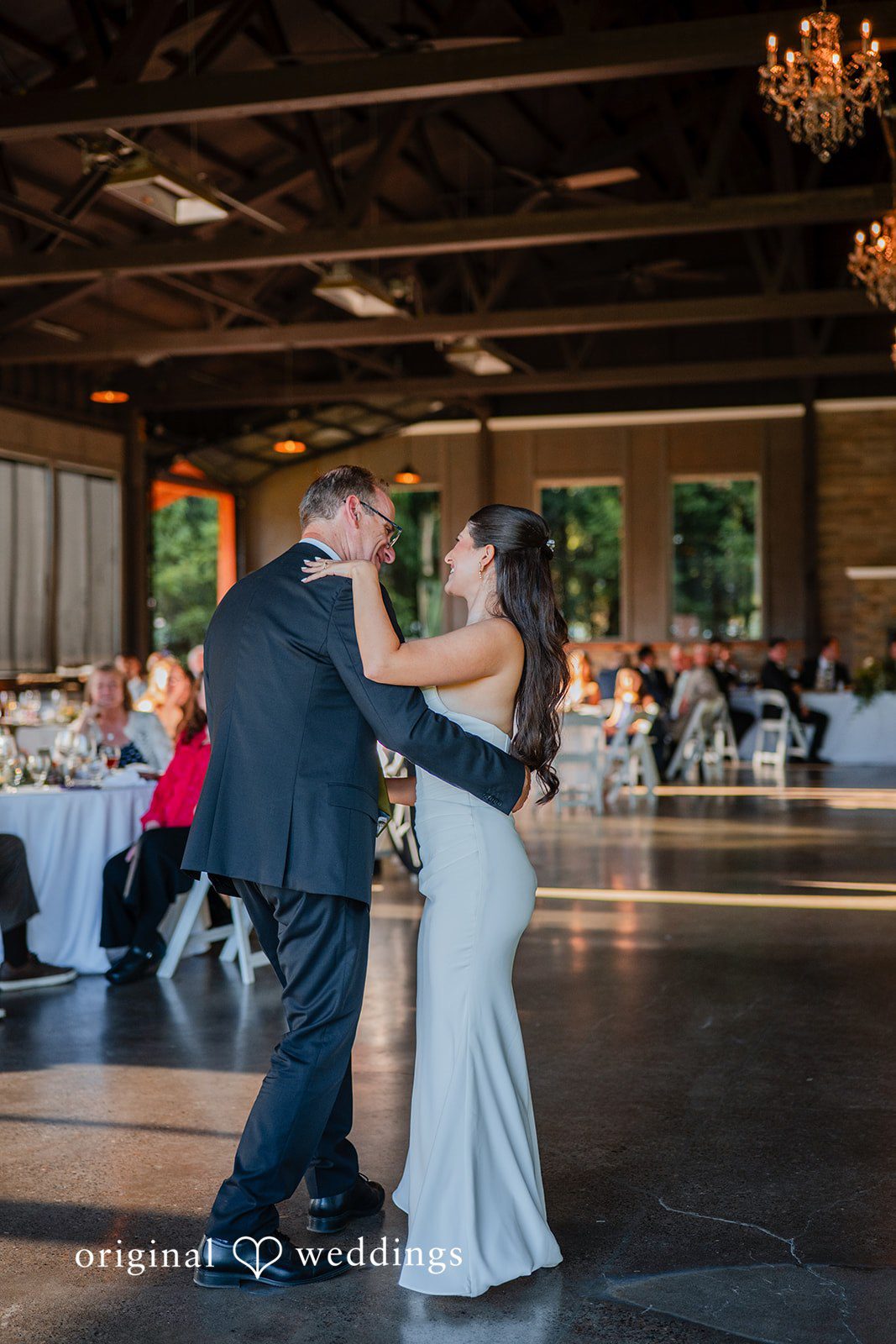 Zechariah + Tova A man and bride dancing together at reception hall filled with guests.