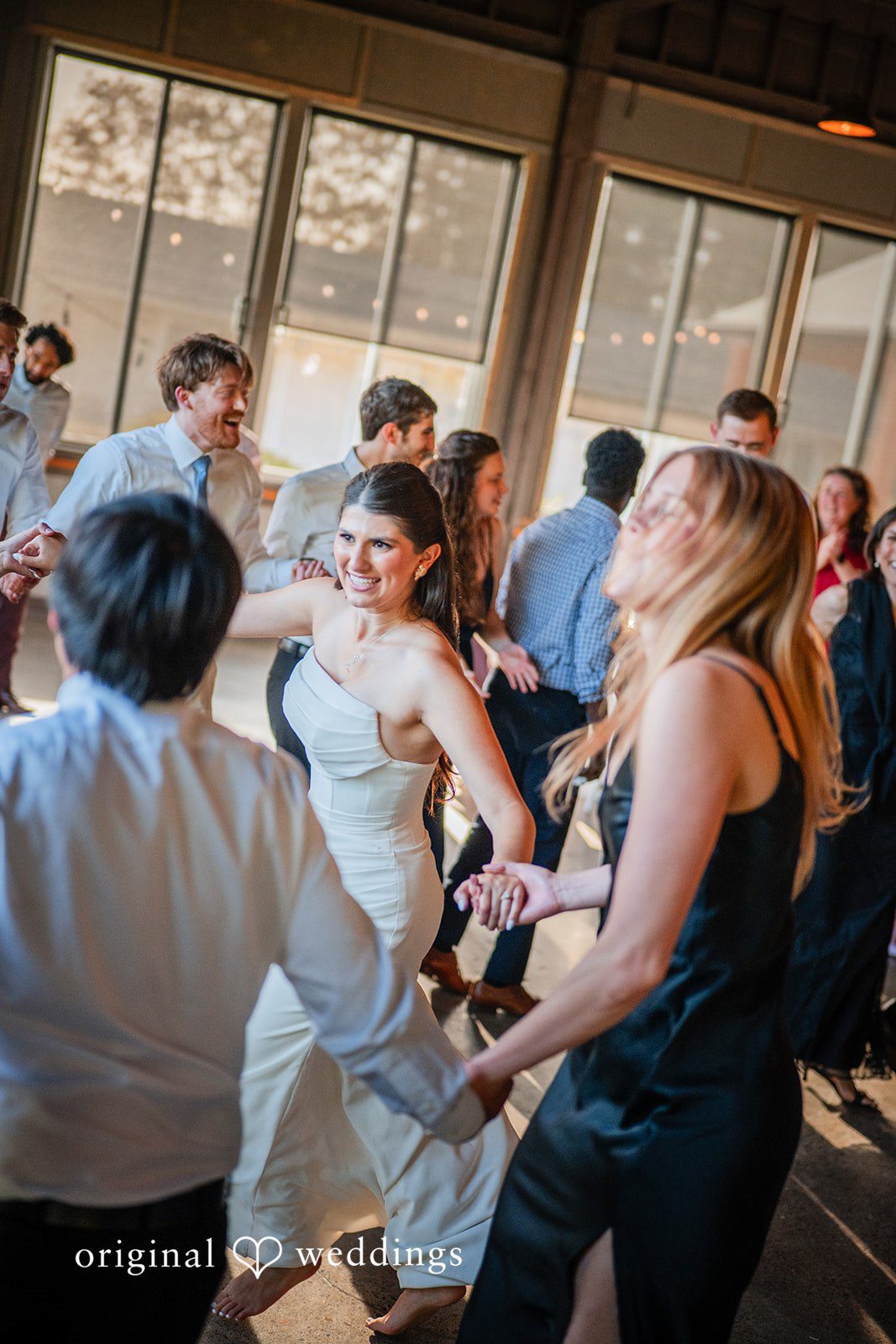 Zechariah + Tova A lively crowd of wedding guests dancing together during a reception celebration.