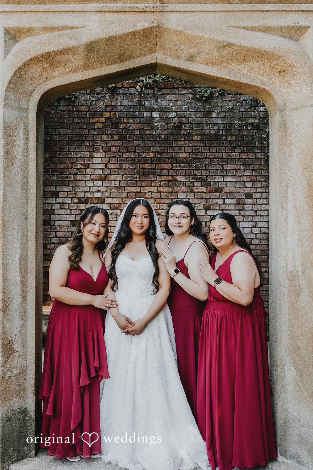 Sharmaine + Ronald A bride posing for a group photo with four bridesmaids in red dresses.