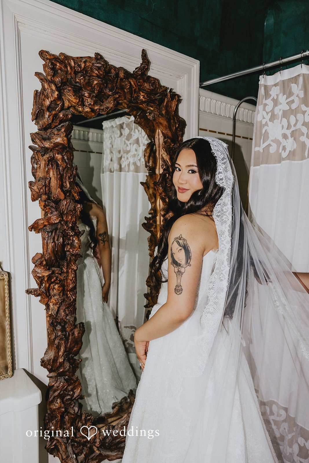 Sharmaine + Ronald A bride posing in front of a mirror with a floral frame.