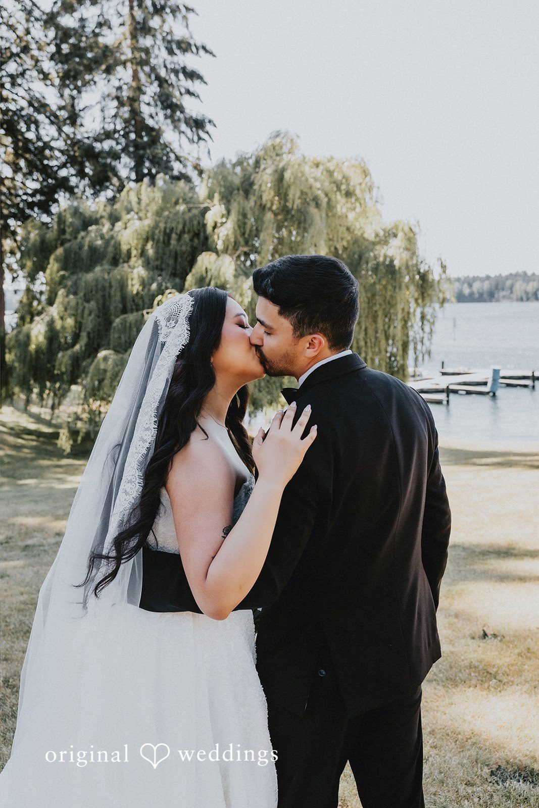 Sharmaine + Ronald A bride and groom sharing an affectionate hug near a waterfront.