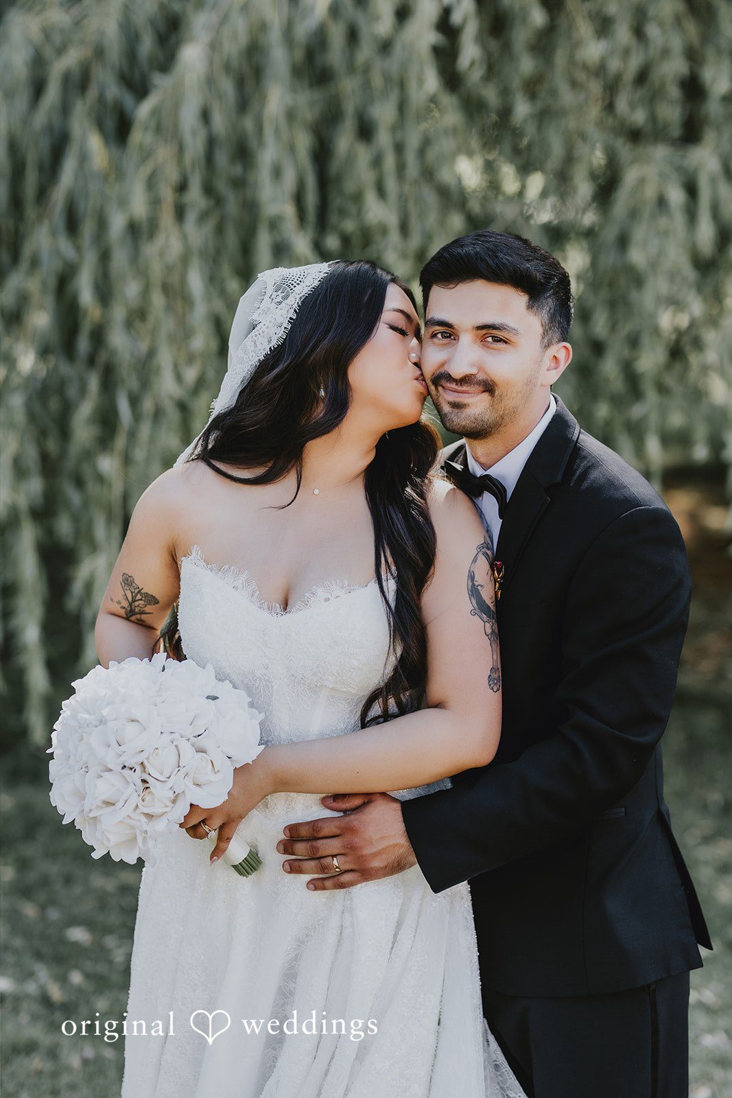 Sharmaine + Ronald A groom wrapping his arms around a smiling bride from behind.