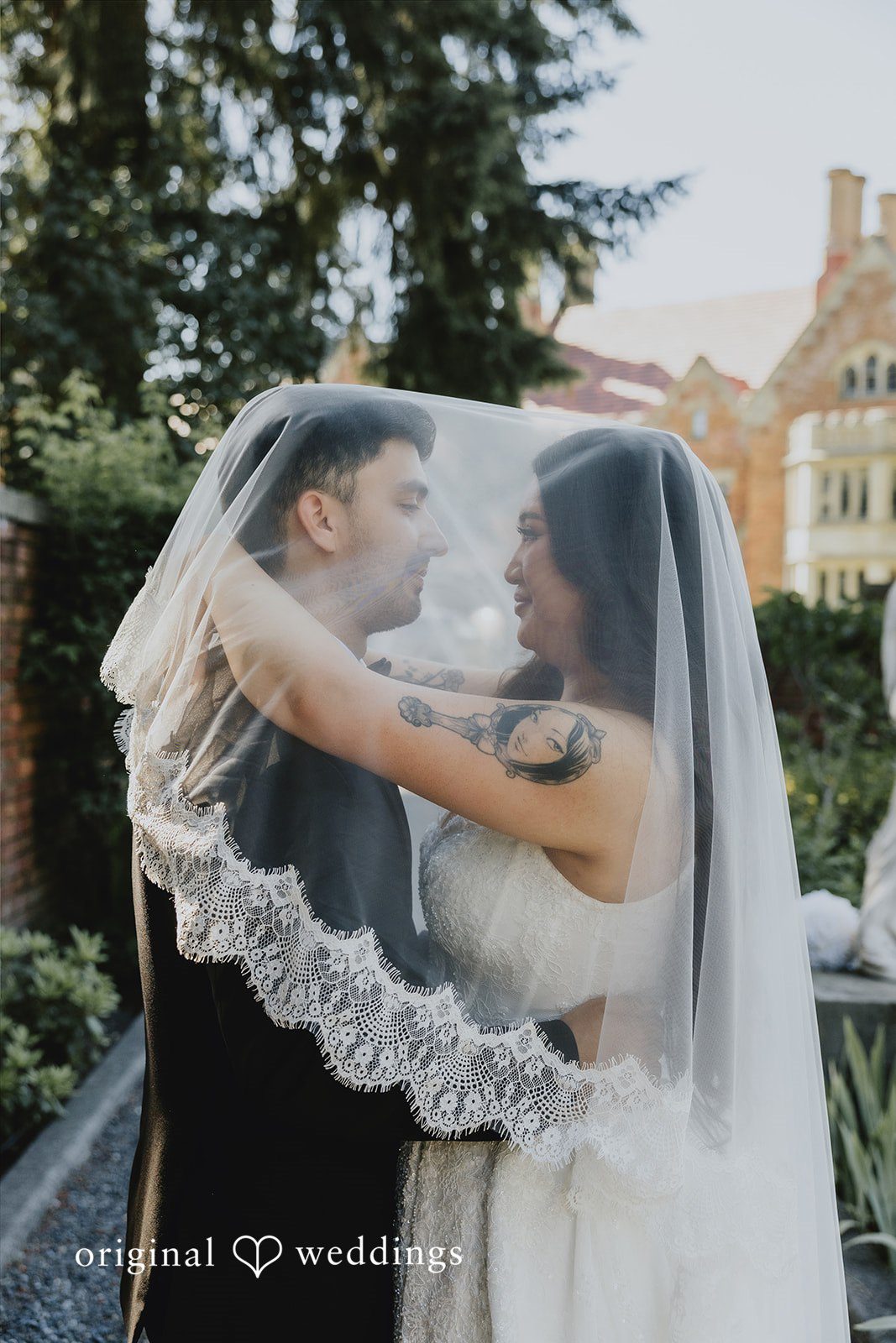 Sharmaine + Ronald A bride and groom sharing a moment underneath a sheer wedding veil.
