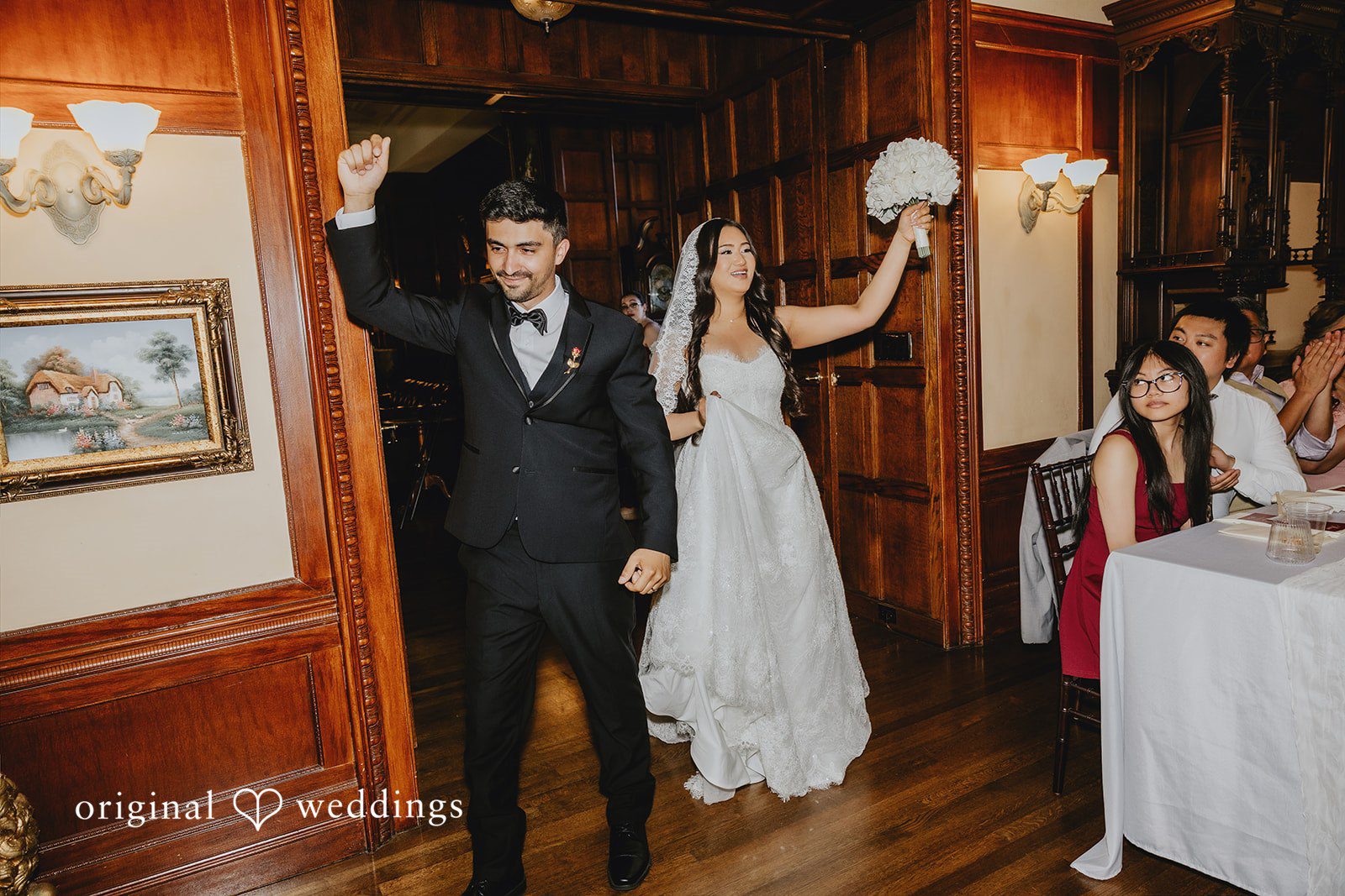 Sharmaine + Ronald A bride and groom raising their hands during a grand reception entrance.
