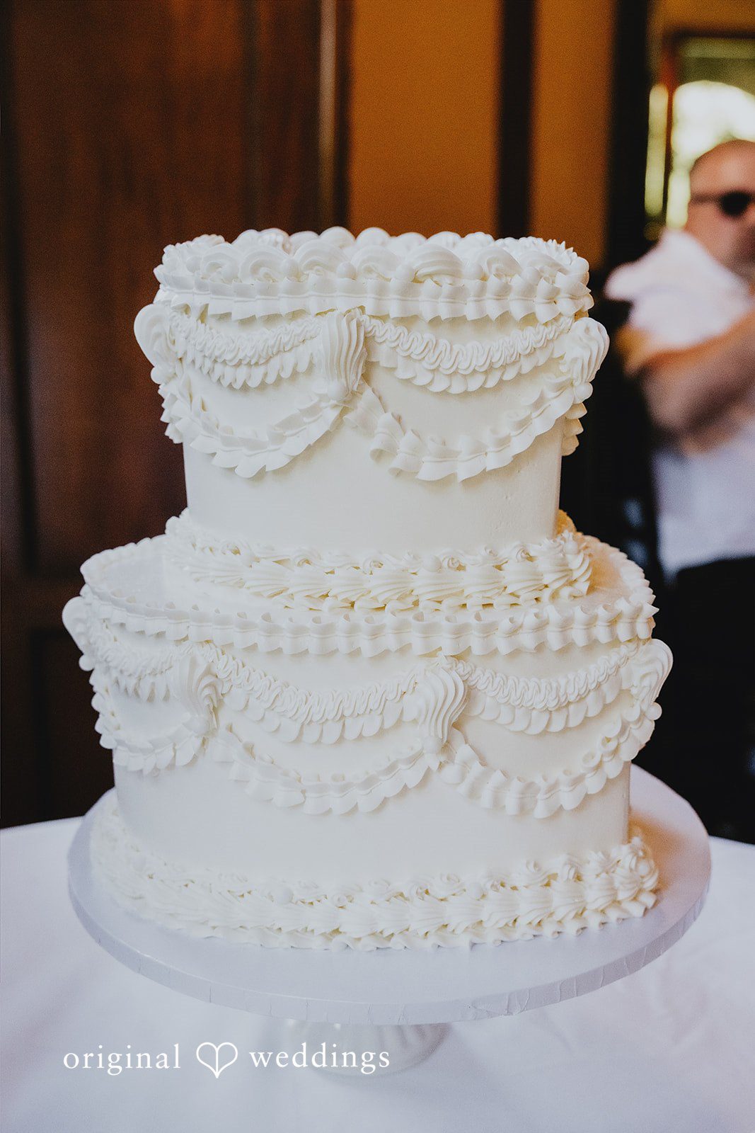 Sharmaine + Ronald A white multi-tiered wedding cake decorated with classic piping.