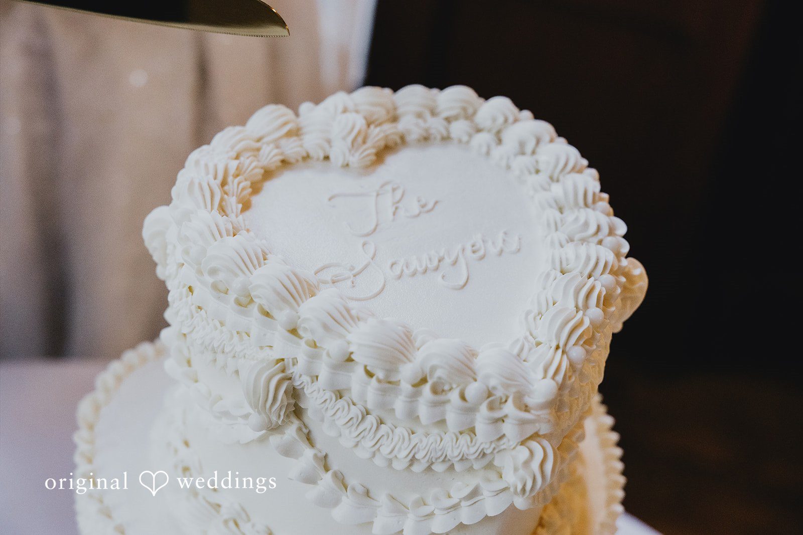 Sharmaine + Ronald A close-up view of textured white frosting on a wedding cake.