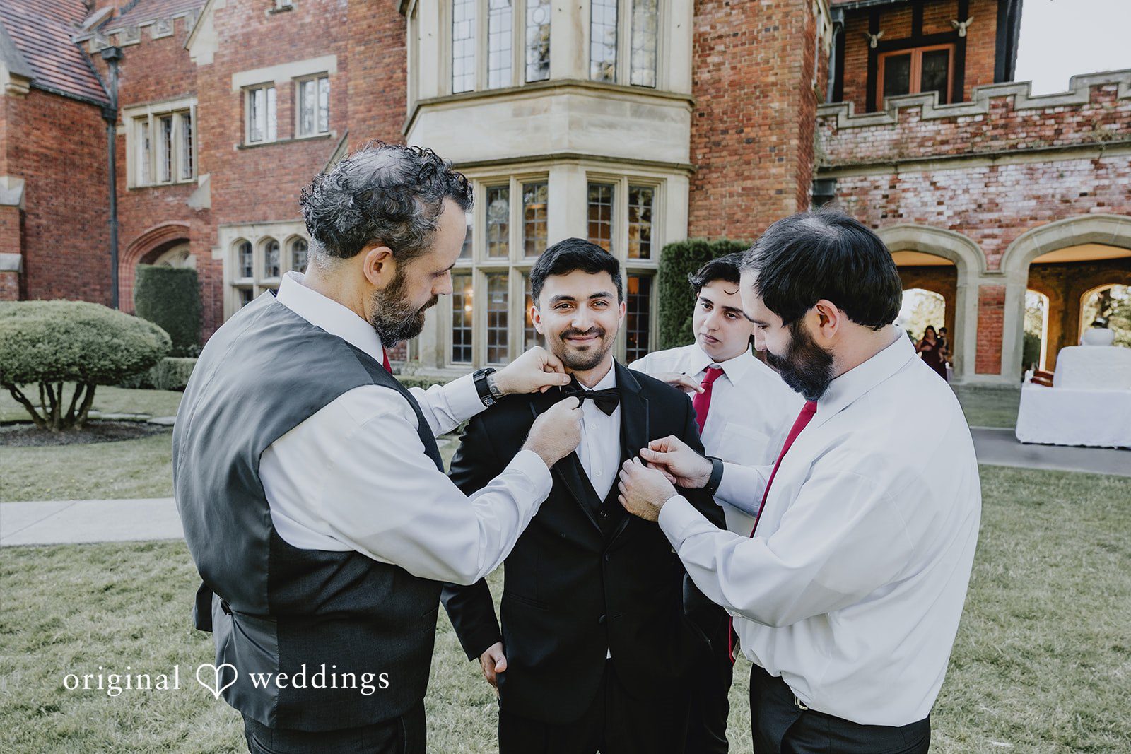 Sharmaine + Ronald A group of men in formal wear gathering and adjusting clothing before an event.