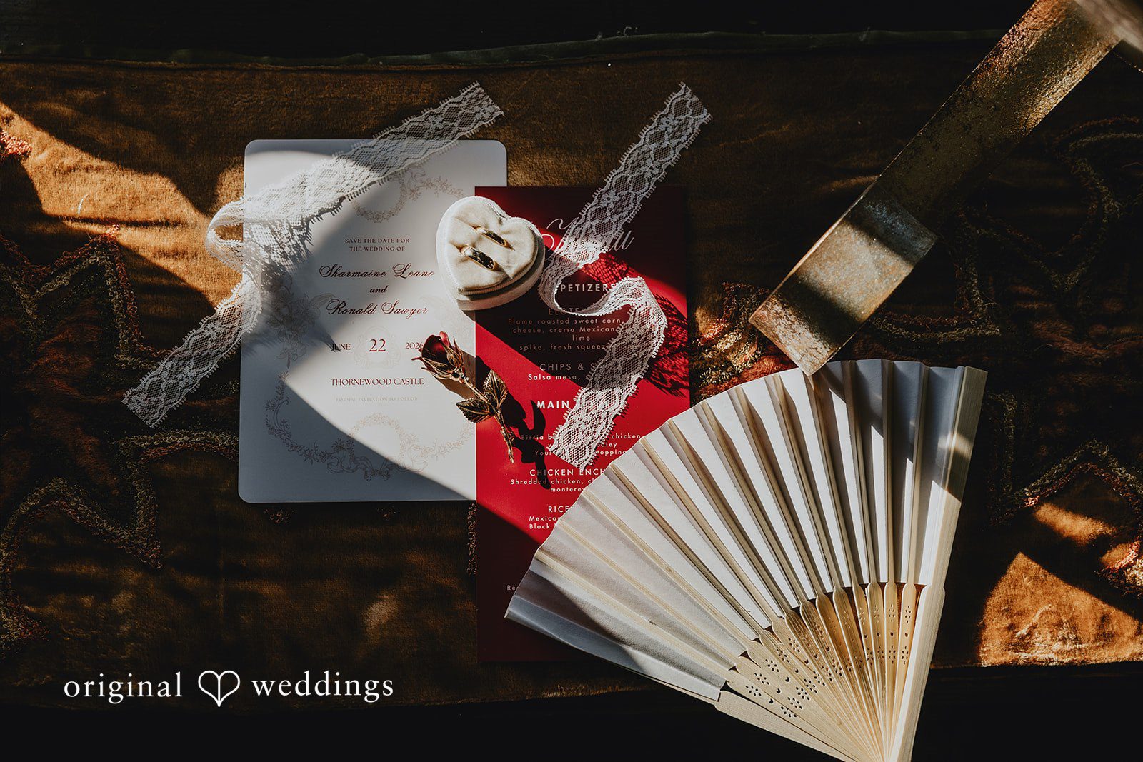 Sharmaine + Ronald A traditional paper hand fan displayed next to event stationery.
