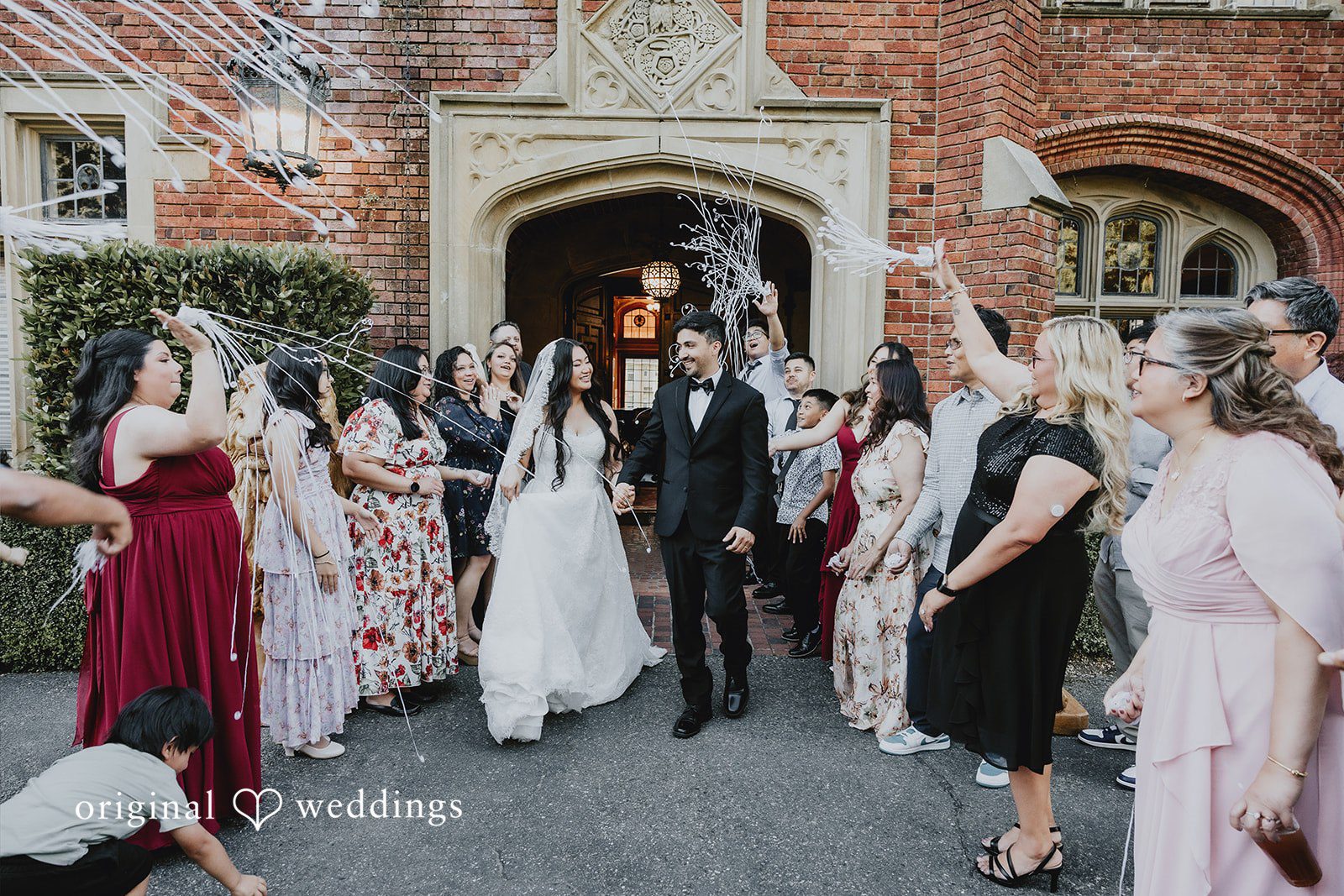 Sharmaine + Ronald Guests cheering and tossing petals over a newlywed bride and groom.
