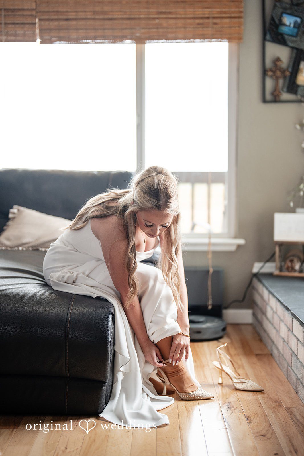 Kayla + Dillon A bride sitting down and adjusting her shoes while getting ready for her wedding.