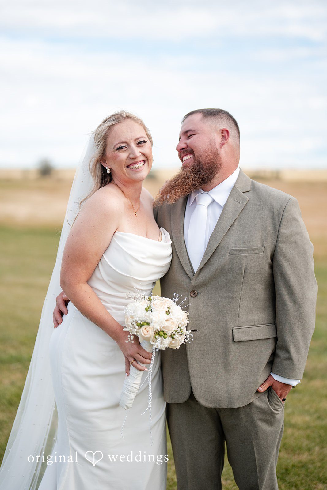 Kayla + Dillon A close-up portrait of a bride and groom embracing and smiling.